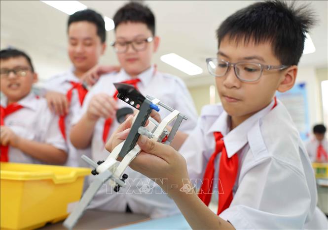 Từ những hình ảnh được tạo ra, học sinh tiến hành lắp ghép mô hình, thử nghiệm, phát hiện lỗi và cùng nhau cải tiến để sản phẩm có thể hoạt động hiệu quả hơn. (Ảnh: Thanh Tùng/TTXVN)